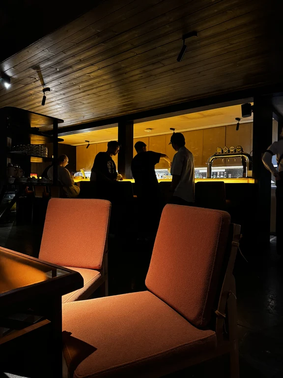 Orange lounge chairs and wooden interior at BAR LOTUS in Chengdu Poly Shiguangli