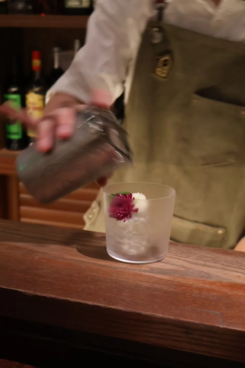 Bartender pouring a flower-garnished cocktail at Chimney in Hangzhou