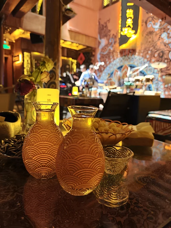 Drinks on a table facing the live-music stage at Yilafu in Lijiang