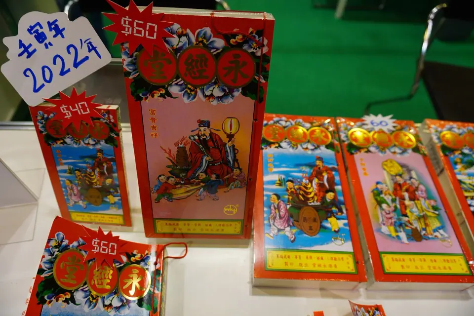 Colorful Chinese almanacs and traditional calendar books displayed at a book fair