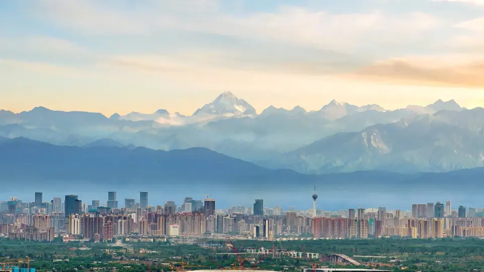 Chengdu skyline beneath distant snow-capped mountains