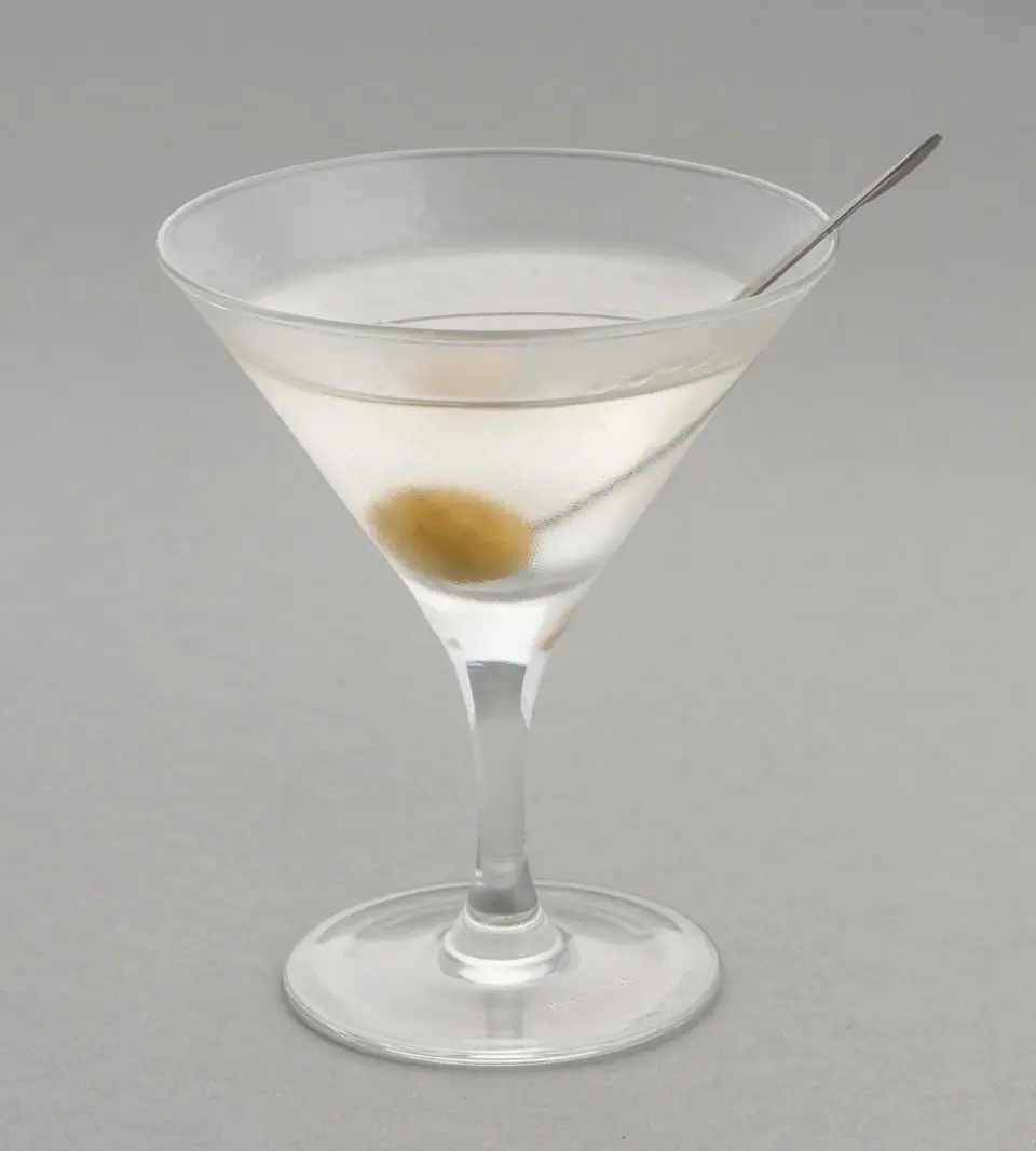 Martini in a stemmed glass with an olive garnish and a cocktail pick