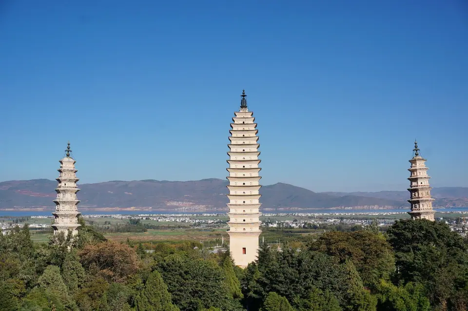 Three white pagodas at Chongsheng Temple with mountains behind Dali