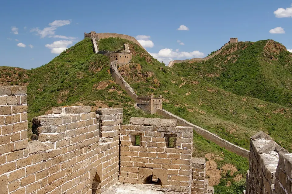 Stone watchtowers and the Great Wall winding over green hills at Jinshanling