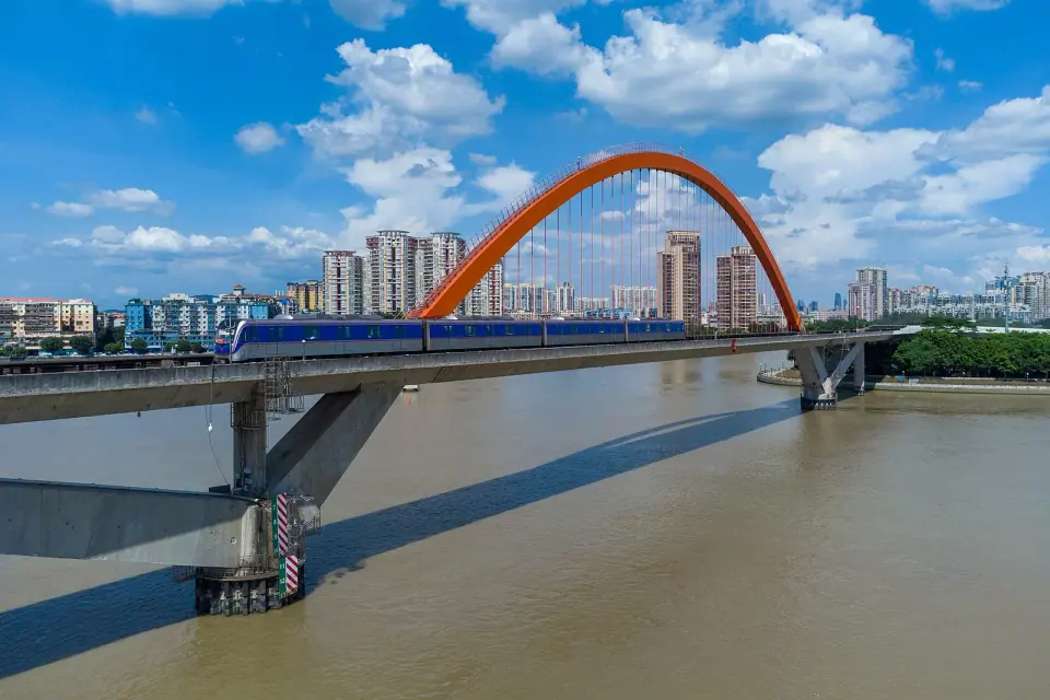 Orange arch of Guangzhou’s Jinshazhou Pearl River Bridge carrying metro tracks across the river