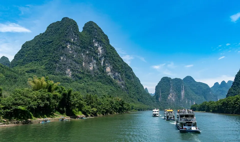 Boats on the Li River beneath green limestone peaks near Guilin