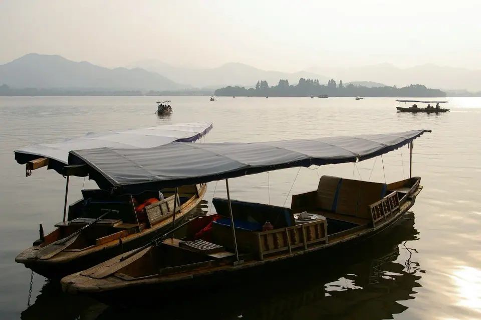 Covered wooden boats moored on Hangzhou’s West Lake before sunset