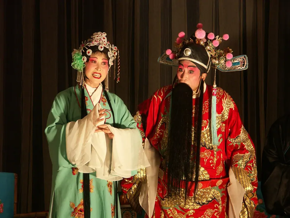 Sichuan opera performers wearing embroidered costumes and ornate headdresses on stage