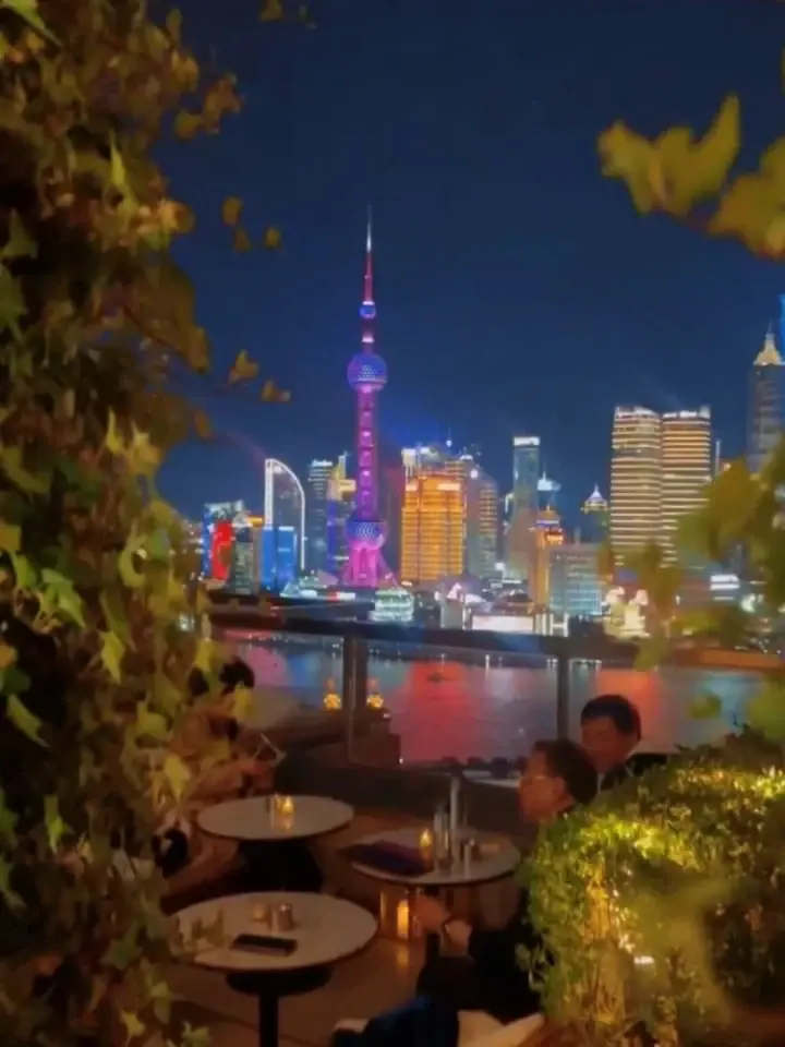 Oriental Pearl Tower and Pudong skyline seen past terrace plants at ROOF Shanghai EDITION