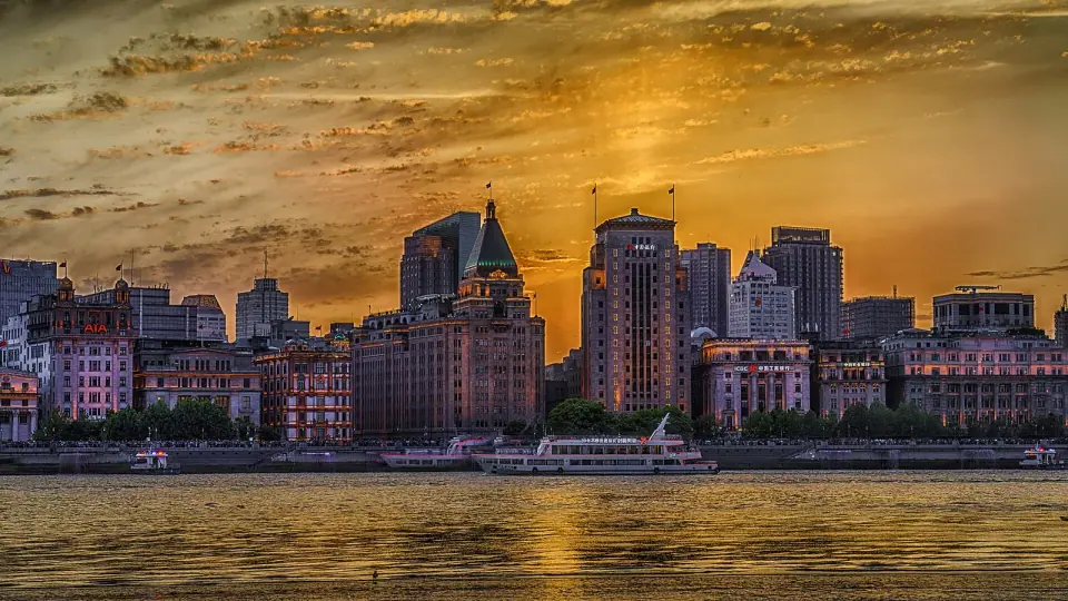 Historic Bund buildings glowing in the evening light beside the Huangpu River