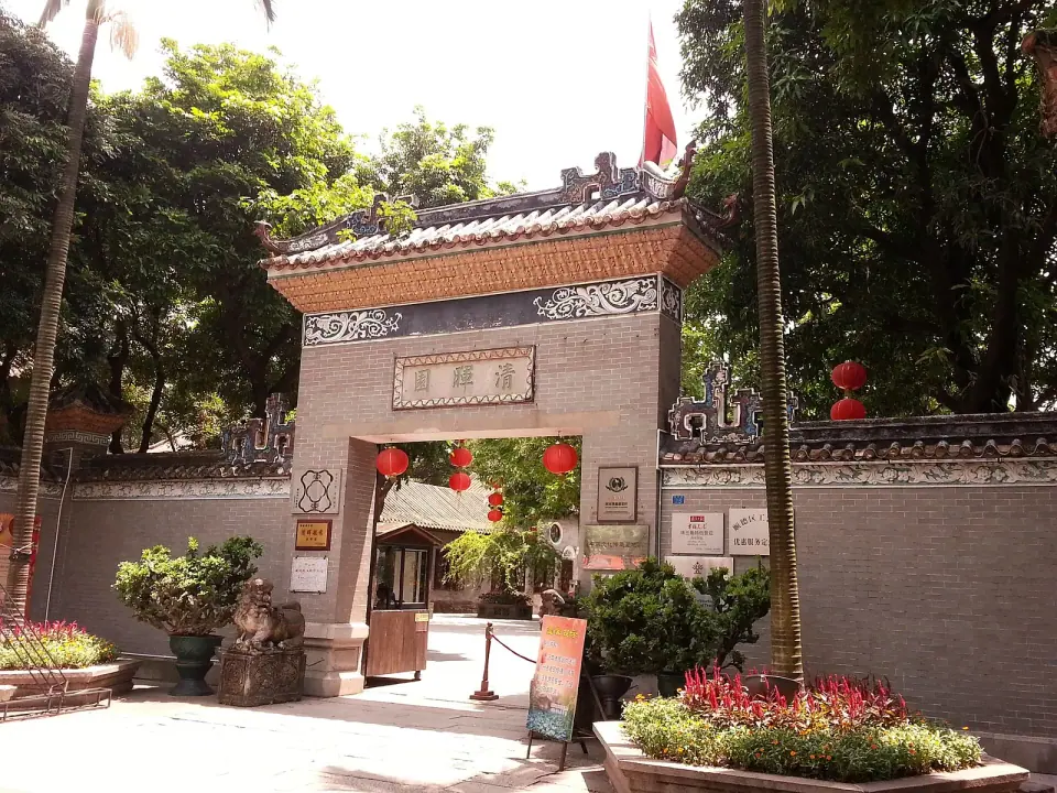 Traditional entrance gate shaded by trees at Qinghui Garden in Shunde