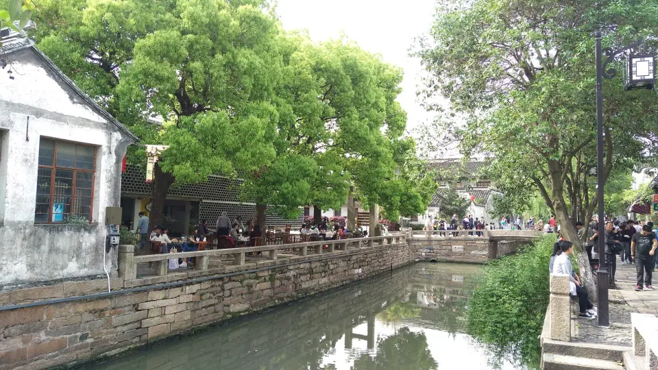 Trees and whitewashed houses beside a canal on Pingjiang Road in Suzhou
