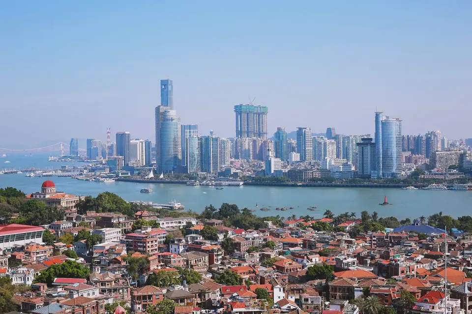 Gulangyu’s red-roofed buildings with the Xiamen skyline across the water
