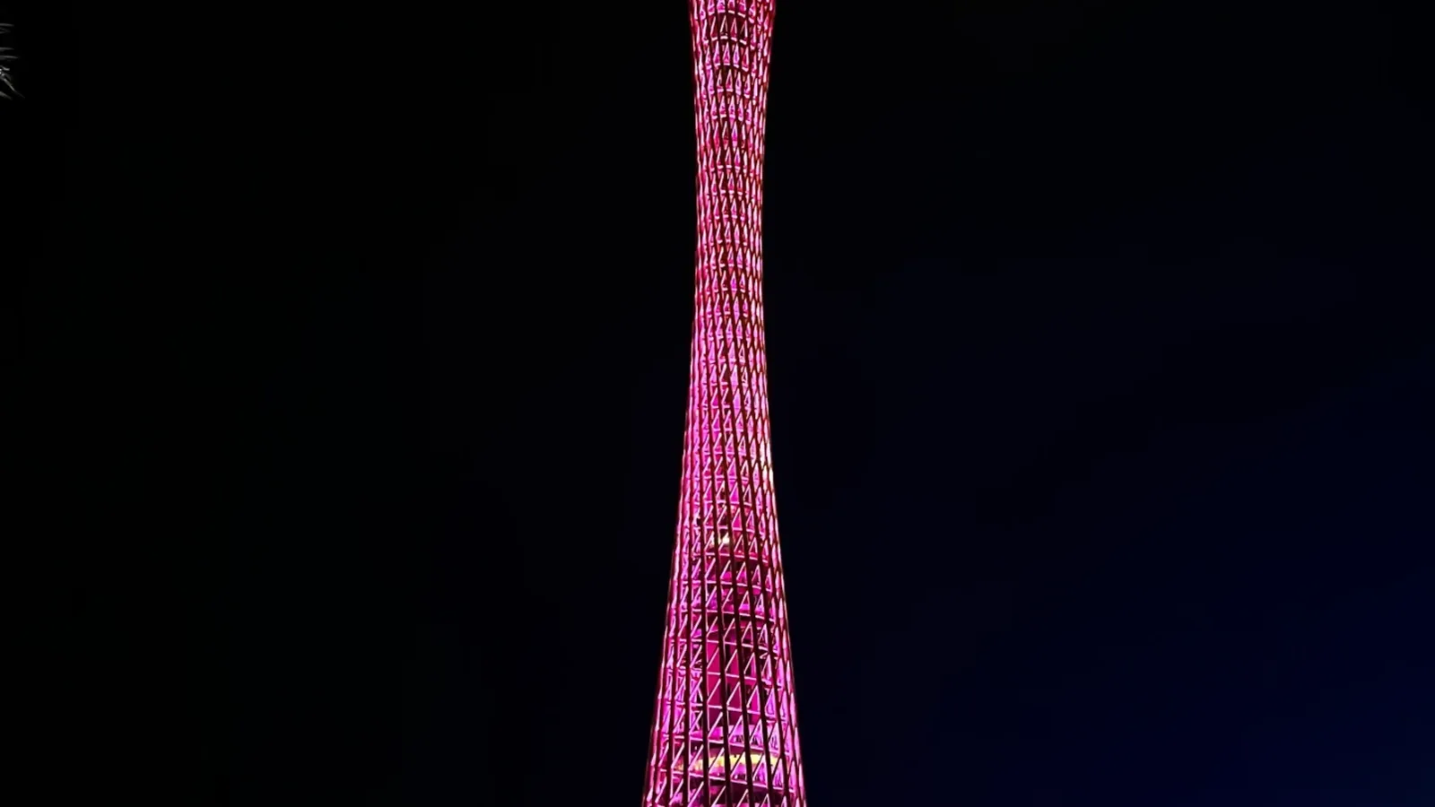 Canton Tower illuminated beside the Pearl River at night