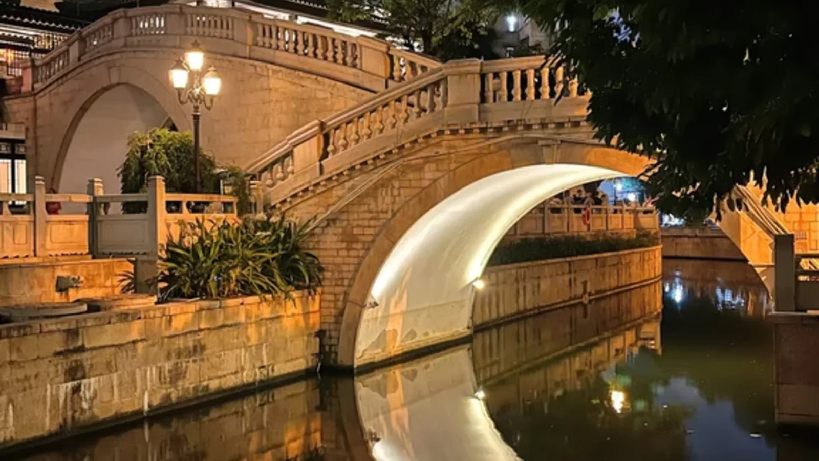 Moon-shaped bridge reflected in the water at Yongqingfang in Guangzhou